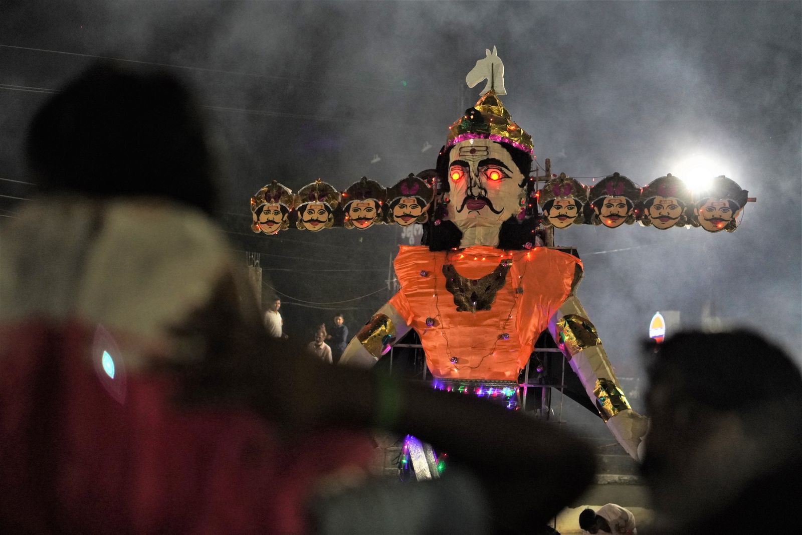 A large illuminated Ravana effigy at a night-time Dussehra celebration.